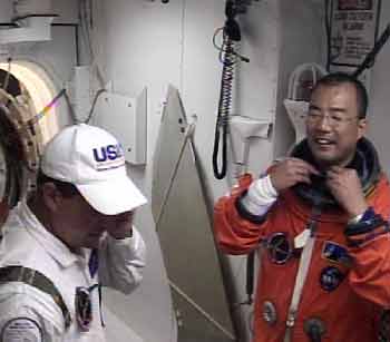 Japanese astronaut Soichi Noguchi smiles as he adjusts his spacesuit after disembarking the shuttle Discovery July 13, 2005. [Reuters]