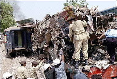 Pakistani soldiers and civilian volunteers search for survivors and bodies within a mangled carriage after a train crash in Ghotki. 