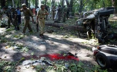 Indian soldiers walk at the scene of a suicide attack in Srinagar July 20, 2005. A suicide bomber slammed a car into a military jeep in Indian Kashmir on Wednesday, killing six people, including four soldiers, and wounding 16 others, police and witnesses said. 