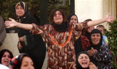 Friends and relatives mourn the deaths of constitution drafting Committee member Mijbil Issa and committee adviser Dhamin Hussein al-Obeidi as their coffins return to their home village of Al-Ryd, Wednesday, July 20, 2005, 35 kms (20 miles) southwest of the northern Iraqi city of Kirkuk. 