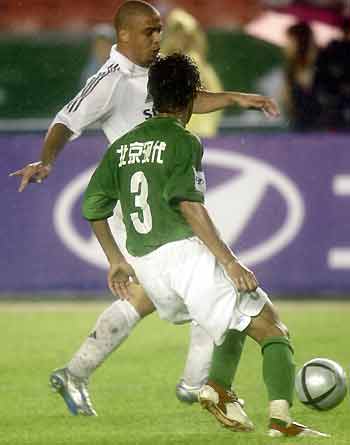 Ronaldo of Real Madrid (in white) fights for the ball with Zhang Shuai of Beijing Hyundai during a friendly match at the Worker's Stadium in Beijing on Saturday, July 23, 2005. [Xinhua] 