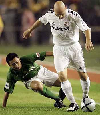 Gao Leilei of Beijing Guoan and Gravesen of Real Madrid fight for the ball during a friendly match at the Worker's Stadium in Beijing on Saturday, July 23, 2005. [Xinhua]