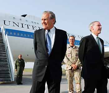 U.S. Secretary of Defense Donald Rumsfeld (L) stands with U.S. Ambassador Stephen Young (R) and U.S. Army Colonel Randy Kee (C) as he arrives in Bishkek, Kyrgyzstan July 25, 2005. Rumsfeld said on Monday Washington would keep military bases in Central Asia, while officials moved to dispel fears it wants permanent facilities in the region. [Reuters]
