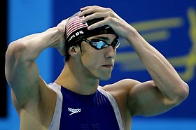 U.S. swimmer Michael Phelps adjusts his cap before swimming in the men's 200m freestyle finals at the World Aquatic Championships in Montreal, July 26, 2005.