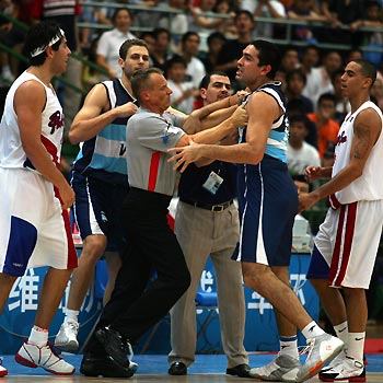 Referees hold back Argentina's basketball players (in blue) and Puerto Rican players (in white) as they argue during a Stankovic Cup game in Beijing July 31, 2005. Fighting erupted at Beijing Capital Gymnasium on Sunday after Argentina's Leonardo Gutierrez was knocked down by Puerto Rico's Hctor Valenzuela. Argentina beat Puerto Rico 86-79. 