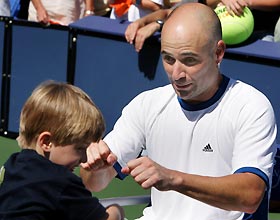 U.S. player Andre Agassi celebrates his win in the final of the Mercedes Benz Cup with his three-year-old son Jaden, in Los Angeles, July 31, 2005. Agassi defeated Gilles Muller of Luxembourg 6-4 7-5. [Reuters]