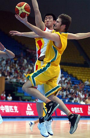 Mark Worthington (front) is fouled by Wang Bo of China while going for a layup during a Stankovic Continental Champions Cup basketball game in Beijing July 31, 2005. Australia held back China's effort to win the third place of the Stankovic Cup with a 71-58 win on Sunday. [newsphoto]