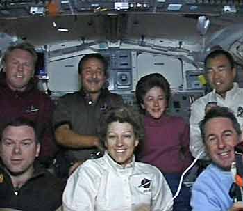 Astronaut Soichi Noguchi of Japan (top, R) answers a question during a crew news conference with fellow crew members (front row, L-R) Pilot James Kelly, Commander Eileen Collins, Steve Robinson along with (back row, (L-R) Andy Thomas of Australia, Charlie Camarda, Wendy Lawrence and Noguchi on the flight deck of Discovery August 7, 2005. [Reuters]