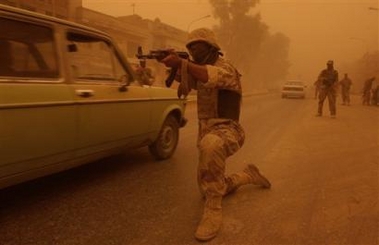 Iraqi soldiers secure checkpoints during a massive sandstorm, Monday, Aug. 8, 2005, in Baghdad, Iraq. Occasional sandstorms create breathing difficulties and reduce visibility to meters causing airports to close and road traffic to reduce to a crawl. (AP