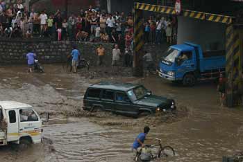 Automobiles are trapped under the crossroad. A heavy rain hit Taiyuan, capital of North Chinas Shanxi Province, on Friday, August 12,2005, bringing much inconveniences to transportation and local residents. [newsphoto]