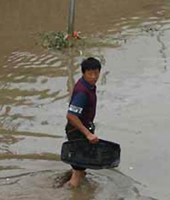 A man finds his motor saddle in the rainwater. A heavy rain hit Taiyuan, capital of North Chinas Shanxi Province, on Friday, August 12,2005, bringing much inconveniences to transportation and local residents. [newsphoto]