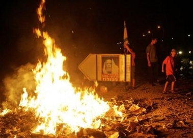Jewish settlers burn trash and maps of Gaza they took from an army vehicle near the entrance of the Jewish settlement of Neve Dekalim in the Gush Katif bloc of settlements in the southern Gaza Strip shortly after midnight Monday Aug. 15, 2005. 