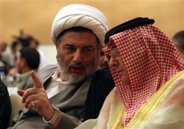 Iraq's leader of the constitution draft committee Humam Hamoudi, left, speaks with Shiite United Iraqi Allies' political leader Sami al- Majoun during a meeting with the National Assembly on the eve of the constitution draft deadline, Monday, Aug. 15, 2005, in Baghdad, Iraq.