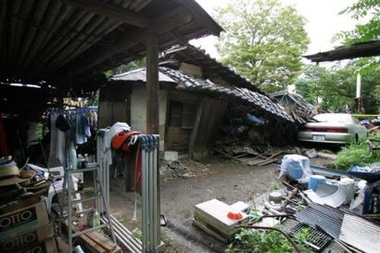 A collapsed house lies on the ground following a quake that shook earlier Tuesday, Aug. 16, 2005. Kazo , North of Tokyo.