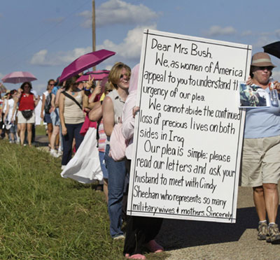 Dozens of women march with a giant letter addressed to U.S. first lady Laura Bush along a road towards the ranch of vacationing U.S. President George W. Bush in Crawford, Texas, August 18, 2005. Dozens of letters, addressed to first lady Bush appealing for her compassion to influence President Bush, were handed to White House representative Bill Burck after the women marched to a police checkpoint near the ranch. [Reuters]