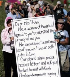 Dozens of women march with a giant letter addressed to U.S. first lady Laura Bush along a road towards the ranch of vacationing U.S. President George W. Bush in Crawford, Texas, August 18, 2005. Dozens of letters, addressed to first lady Bush appealing for her compassion to influence President Bush, were handed to White House representative Bill Burck after the women marched to a police checkpoint near the ranch. [Reuters]