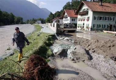 A man passes a street that has been destroyed by floods from the River Loisach in Eschenlohe, southern Germany, on Wednesday, Aug. 24, 2005. 