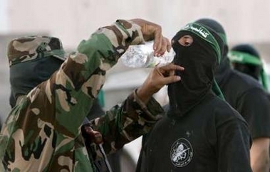An armed Palestinian from the military wing of Hamas group drinks water during military exercise in the north of Gaza Strip August 25, 2005.