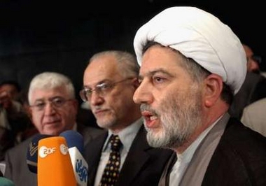 Shi'ite cleric Humam Hammudi (R), head of the Constitutional Committee in Iraqs Transitional National Assembly (TNA), speaks to reporters as Deputy Speaker Hussein al-Shahristani (C) and Kurdish lawmaker Faud Massum (L) listen during a news conference after an assembly session in Baghdad August 28, 2005. 