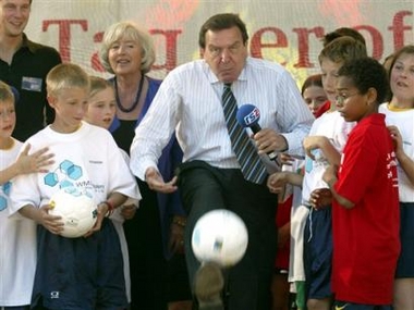 German Chancellor Gerhard Schroeder kicks a soccer ball as he tours his garden in the Chancellery during the annual open day of the government in Berlin, Saturday, Aug. 27, 2005. Ministries and government offices are open to the public for the weekend. (AP