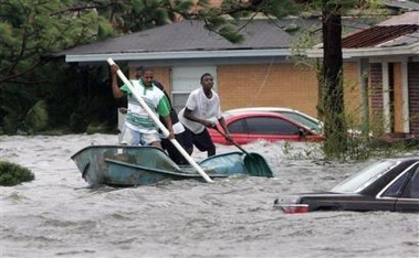 Elvin Duckworth, left, Jonathan Harvey, center, and Leonard Harvey paddle a row boat through a flooded street in their Gulfport, Miss, neighborhood after Hurricane Katrina struck the Gulf Coast Monday, Aug. 29, 2005 . (AP