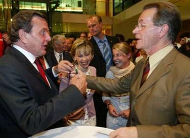 German Chancellor Gerhard Schroeder (L) jokes with Franz Muentefering (R), chairman of Germany's Social Democratic Party (SPD), as Doris Schroeder-Koepf (2L) laughs during a party organised by the SPD, ahead to their party convention in Berlin, August 30, 2005.