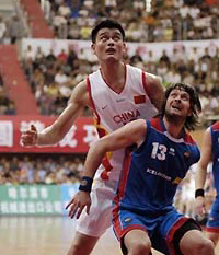 Yao Ming of China (back) looks at the ball as he is guarded by Hlynur Baeringsson of Iceland during a friendly match between the Chinese and Icelandic national teams in Harbin, northeast China's Heilongjiang province, August 30, 2005.