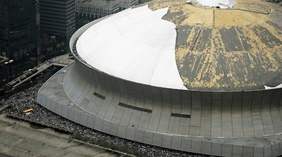 Thousands of residents are shown gathering outside the storm damaged Louisiana Super Dome in New Orleans September 1, 2005. Rotting bodies littered New Orleans' streets on Thursday and troops headed in to control looting and violence, as thousands of desperate survivors of Hurricane Katrina pleaded to be evacuated from the flooded city, or even just fed.