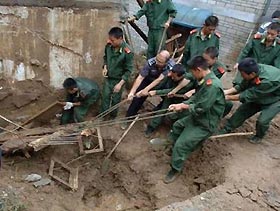 Chinese soldiers remove wreckage from a collapsed farmhouse in Yuexi county, in east China's Anhui province, September 4, 2005. 