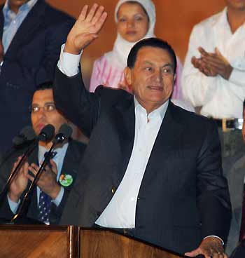 Egyptian President Hosni Mubarak (C) waves to supporters during a rally in Cairo, Egypt September 4, 2005. Campaigning drew to a close on Sunday in Egypt's first multi-candidate presidential election, which most Egyptians have little doubt will give Mubarak a fifth six-year term in office. [Reuters]