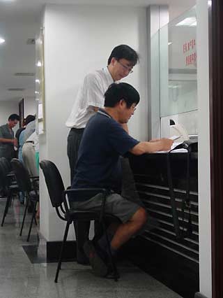 Professor Xie Baisan (in the chair) files prosecution to the court with his layer. [Sohu]
