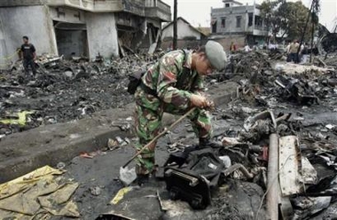 An Indonesian soldier searches the wreckage of Mandala Airlines flight A330 which crashed moments after taking off from Medan, Indonesia enroute to Jakarta Tuesday Sept. 6, 2005 in Medan. 