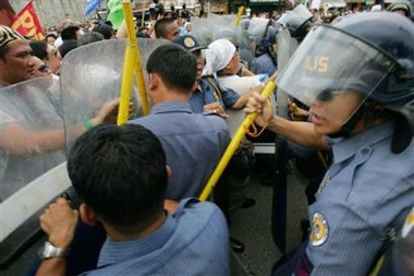 Riot police officers block surging protesters who tried to march towards the Philippine Congress at suburban Quezon city, north of Manila, Tuesday, Sept. 6, 2005 to call for the ouster of Philippine President Gloria Macapagal Arroyo while legislators debate the impeachment complaints against her.