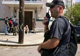 A Dublin (Ohio) police officer speaks into radio during a patrol in the Bywater neighborhood, advising residents of an impending forced evacuation September 7, in New Orleans September 7, 2005. 