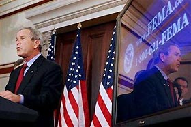U.S. President George W. Bush is reflected in a monitor as he announces measures to provide more aid to families displaced by Hurricane Katrina September 8, 2005 in Washington.