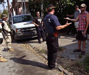 Police and Border Patrol agents try to convince a man to evacuate New Orleans in the city's Bywater neighborhood September 9, 2005. Recovering the dead took priority over coaxing the living out of New Orleans on Friday as the Bush Administration replaced the head of its emergency management team in a political storm following Hurricane Katrina. Holdouts remain while rescue units search for those wishing to evacuate. [Reuters]