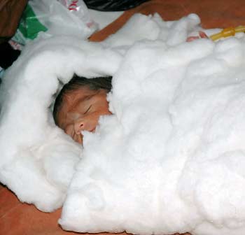 A newly born child suffering from Japanese Encephalitis lies at an emergency ward of a hospital in the northern Indian city of Allahabad September 11, 2005. [Reuters]