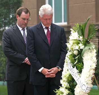 Dressed in a dark suit, former U.S. president Bill Clinton (front) bows in prayer during a service commemorating the September 11, 2001 attacks, at the U.S. embassy in Beijing, September 11, 2005. Clinton is in Beijing as part of a four-day, seven-city visit to China and gave a short speech warning against extremist terrorism. Behind him is David Sedney, U.S. Charge d'Affaires. [Reuters]