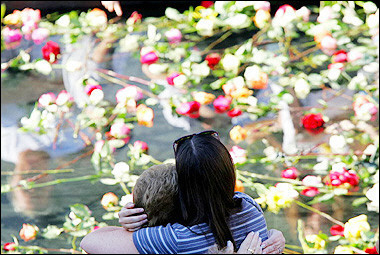 A couple embrace at the reflective pool on the footprint of the South Tower of the World Trade Center at Ground Zero on the fourth anniversary of the 9/11 terrorist attacks in New York City.(AFP