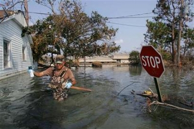 Pedro Uranga of the National Guard of New Mexico walks through a flooded street in Port Sulphur, 30 miles (48 km) south of New Orleans, September 10, 2005. Emergency workers collected the dead of New Orleans on Saturday, as hopes rose that the toll from Hurricane Katrina would fall short of the calamity once feared.