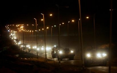 A convoy of Israeli armored military vehicles leaves the Gaza Strip through the Kissufim Crossing into Israel early Monday, Sept. 12, 2005.