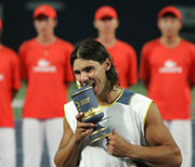 Spain's Rafael Nadal bites the China Open trophy during the prize presentation ceremony at the Beijing Tennis Centre in Beijing September 18, 2005.