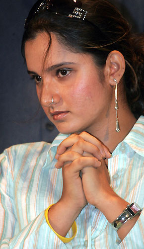 Indian tennis player Sania Mirza watches Indian schoolgirls as she attends a school reception in the eastern India city of Kolkata, previously known as Calcutta September 19, 2005. Mirza will receive extra security after an Islamic group opposed to her on-court dress threatened to stop her from playing in next week's WTA event, police said on Friday. [Reuters]
