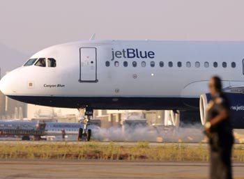 A JetBlue airliner with faulty landing gear touched down safely Wednesday evening at Los Angeles International Airport after circling the region for three hours with its front wheels turned sideways and unable to retract into the plane.