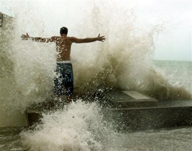 Joe McGee stands in the pounding surf at the Southern Most Point in Key West, Fla. Tuesday, Sept. 20, 2005, as Hurricane Rita neared the lower Florida Keys. (AP