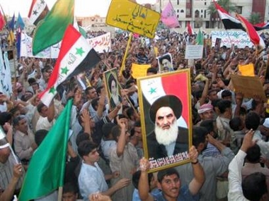 Iraqi demonstrators hold banners in support of the draft constitution and pictures of Iraq's highest religious authority, the Grand Ayatollah Ali al-Sistani, in Kut, southeast of Baghdad, August 29, 2005. 