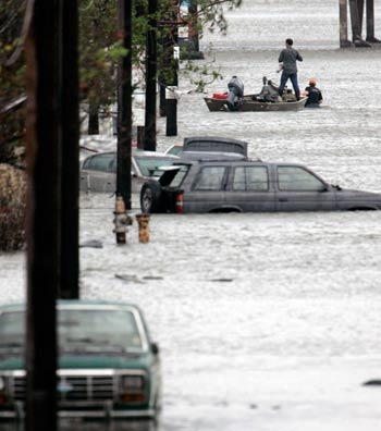 An unidentified camera crew makes its way by boat through the newly flooded Ninth Ward in New Orleans, September 23, 2005. Texas officials warned of catastrophe and an already devastated New Orleans suffered renewed flooding as weakened levees gave way in the hours before Hurricane Rita's expected strike at the U.S. Gulf Coast. [Reuters]