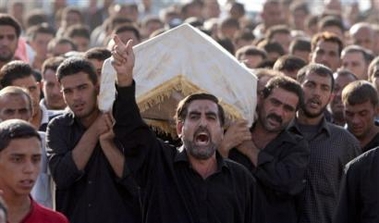 An Iraqi man shouts leading mourners carrying the coffin of a man killed in Baghdad's Sadr City, a Shiite slum in the eastern part of the capital, during overnight fighting Sunday Sept. 25, 2005.