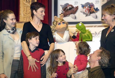 Jim Henson's children Heather (L), Lisa (2nd L, rear), and Brian (2nd R), stand with Executive Vice President of the United States Postal Service Anita J Bizzotto (R) as Henson's grandchildren Julian (2nd L, front), Ginger (C), and Amelia talk to Kermit The Frog and Miss Piggy, following the unveiling of a USPS stamp collection honoring Jim Henson at the Academy of Television Arts & Sciences in Los Angeles, California September 28, 2005. Jim Henson, who passed away in 1990, first created the puppet characters known as Muppets in 1955 and had his creations go on to star on television in "Sesame Street," "The Muppet Show," "Fraggle Rock," and "Jim Henson's Muppet Babies," along with several feature films and holiday specials. 