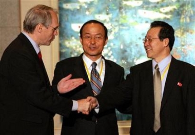 U.S. Assistant Secretary of State Christopher Hill (L) shakes hands with North Korea's chief negotiator Kim Gye Gwan (R) as South Korean Deputy Foreign Minister Song Min-soon looks on at the close of talks over North Korea's nuclear crisis held at the Diaoyutai State Guest House in Beijing, China September 19, 2005.